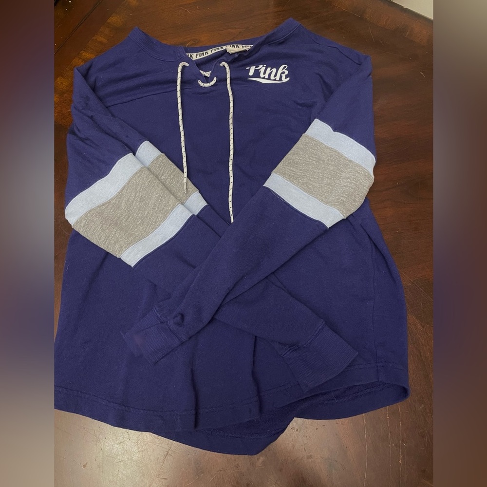 Pink long sleeve shirt. Blue color with light blue and grey sleeves. Size medium